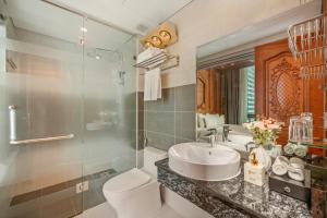 a bathroom with a sink and a toilet and a mirror at Monalisa Luxury Hotel in Da Nang