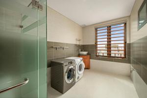 uma lavandaria com uma máquina de lavar roupa e uma janela em Monalisa Luxury Hotel em Da Nang