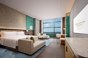 成都市にあるGrand Mercure Chengdu Eastのベッドとソファ付きのホテルルーム