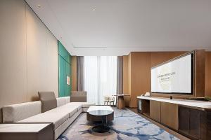 a living room with a couch and a flat screen tv at Grand Mercure Chengdu East in Chengdu