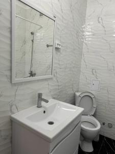 a white bathroom with a sink and a toilet at ЖК Only Sun in Prigorodnyy
