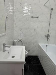 a bathroom with a sink and a toilet and a tub at ЖК Only Sun in Prigorodnyy