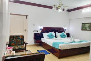 Habitación de hotel con cama y silla en Hotel Mount View, en Kodaikanal