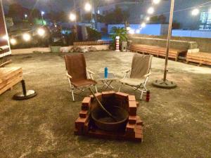 two chairs and a fire pit in a patio at night at The Galaxy Express Nahama ザ・ギャラクシー・エキスプレス・ナハマ in Yokosuka