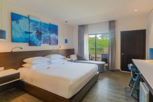 Postel nebo postele na pokoji v ubytování Kuta Beach Club Hotel