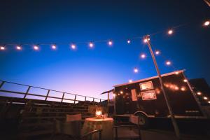 a food truck with lights above a table at night at The Galaxy Express Nahama ザ・ギャラクシー・エキスプレス・ナハマ in Yokosuka