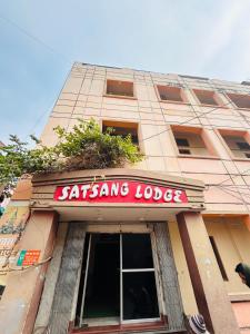 un edificio con un letrero que dice sakura lodge en Satsang Lodge, en Varanasi