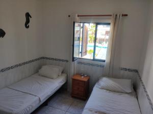 two beds in a room with a window at Victoria Court 2, Los Cristianos in El Guincho