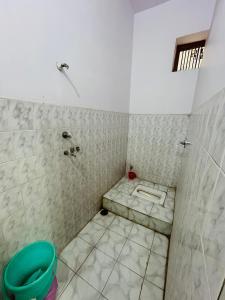 bagno con doccia e pavimento piastrellato di Satsang Lodge a Varanasi