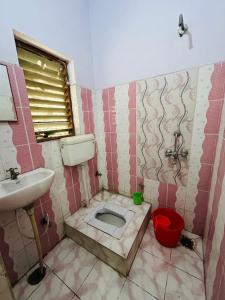 Baño sucio con aseo y lavamanos en Satsang Lodge en Varanasi