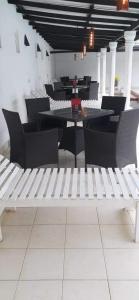 a white bench in a restaurant with tables and chairs at Ocean Villa in Panadura