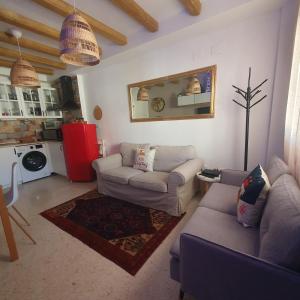 uma sala de estar com 2 sofás e um frigorífico vermelho em Apartamento Rural El Bandolero em El Bosque