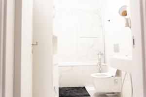 La salle de bains blanche est pourvue de toilettes et d'un lavabo. dans l'établissement Luxury Brand New Win Herastrau, à Bucarest