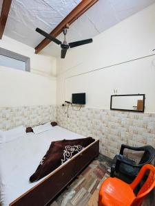 - une chambre avec un lit et une chaise orange dans l'établissement Satsang Lodge, à Varanasi