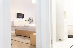 - une chambre blanche avec un lit et une télévision dans l'établissement Luxury Brand New Win Herastrau, à Bucarest
