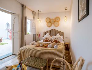 a bedroom with a bed with a yellow and white comforter at Riad El Marah in Marrakesh