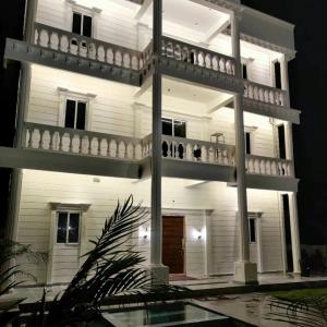 um grande edifício branco com duas varandas e uma piscina em Runaway villa em Hyderabad