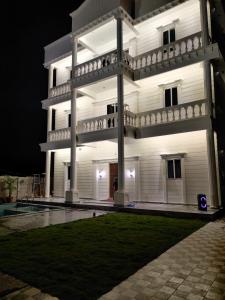 um grande edifício branco à noite com um quintal em Runaway villa em Hyderabad