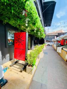 a red sign on the side of a building with plants at BT hotel Kata Beach in Kata Beach