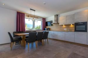 a kitchen with a wooden table and black chairs at Appartements Danijela in Fügenberg