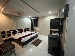 una camera con un letto e una televisione di HOTEL ANAND a Jhansi