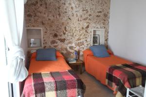 um quarto com 2 camas e uma parede de pedra em ALBALAT em Alaior