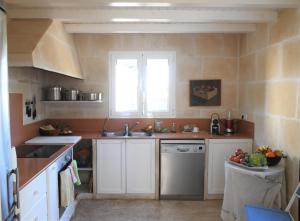 uma cozinha com armários brancos, um lavatório e uma janela em ALBALAT em Alaior