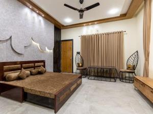 a bedroom with a large bed and two chairs at Skilight Villa in Indore