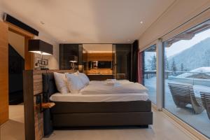 um quarto com uma cama grande e uma varanda em Lavender Hill - Summer holiday & ski chalet/villa em Saalbach-Hinterglemm