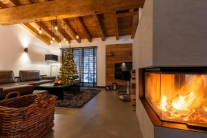a living room with a fireplace and a christmas tree at Lavender Hill - Summer holiday & ski chalet/villa in Saalbach-Hinterglemm