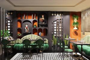 um restaurante com cadeiras verdes e mesas num quarto em Hanoi Center Silk Classic Hotel & Travel em Hanói
