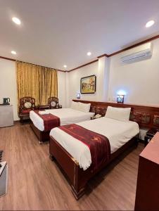 河内Hanoi Asia 2 Long Bien的酒店客房配有两张床和一张书桌