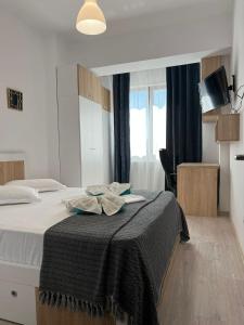 una camera da letto con un letto con una coperta nera sopra di TOD APARTMENTS Palas Mall a Iaşi