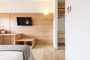 a bedroom with a bed and a tv on a wall at Hotel Toboso Almuñécar in Almuñécar