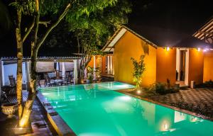烏達瓦拉維的住宿－烏達瓦拉瓦大象休憩酒店，夜间在房子前面的游泳池