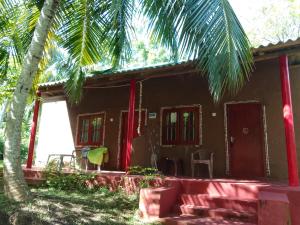 a house with a palm tree in front of it at Peacock Family Stay in Tangalle