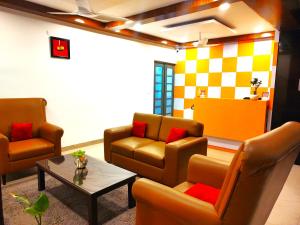 uma sala de espera com duas cadeiras e uma mesa em Athasri Hotel HSR Layout em Bangalore