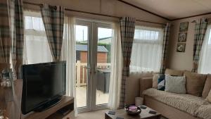 a living room with a flat screen tv and a couch at 149 Holiday Resort Unity 3 bed Entertainment passes included in Brean