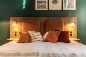 ein Schlafzimmer mit einem Bett mit zwei Kissen darauf in der Unterkunft La Maison OBONO in Le Bono