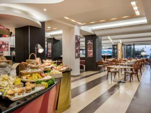 a buffet line with food on display in a restaurant at Esperos Mare Resort in Faliraki