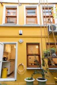 a yellow building with windows and potted plants at La Villa Gardenia : 4Br Villa with Private Garden in Istanbul