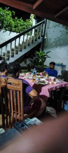 um grupo de pessoas sentadas à mesa a comer em AnandaHomestay em Kandy