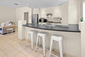 a kitchen with two bar stools and a counter at Beaumont Bliss: 4BR 2 5BA Family Retreat in Glenunga +4 photos