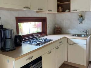 a kitchen with a stove top oven next to a sink at Spacious Chalet in Garderen with Fenced Garden in Garderen