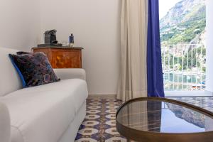 ein Wohnzimmer mit einem weißen Sofa und einem Glastisch in der Unterkunft Hotel Marina Riviera in Amalfi