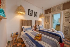 ein Schlafzimmer mit 3 Betten und Spielzeug darauf in der Unterkunft Riad El Marah in Marrakesch