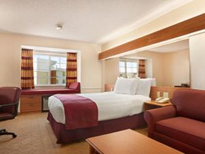 a hotel room with a large bed and a couch at Microtel Inn & Suites by Wyndham Ann Arbor in Ann Arbor