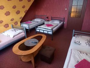 a room with four beds and a table in it at Miltex in Torzym