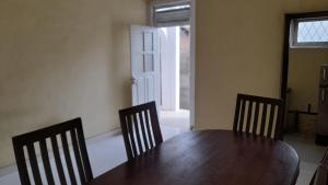 uma sala de jantar com uma mesa de madeira e 3 cadeiras em Kandy Forigners Home Stay em Katugastota