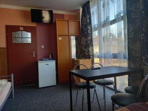 a room with a table and chairs and a refrigerator at Miltex in Torzym